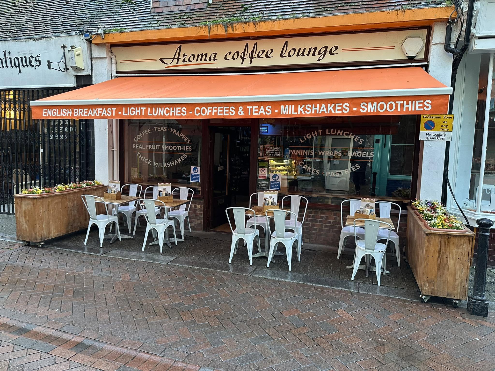 Complete historic Aroma Coffee Lounge sign, orange awning, entrance and outdoor tables on George Street